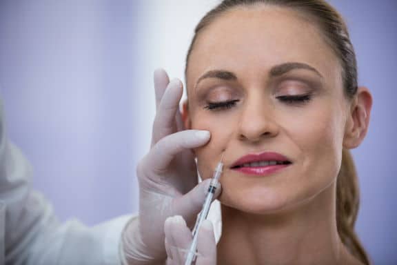 Woman receiving botox injection at clinic
